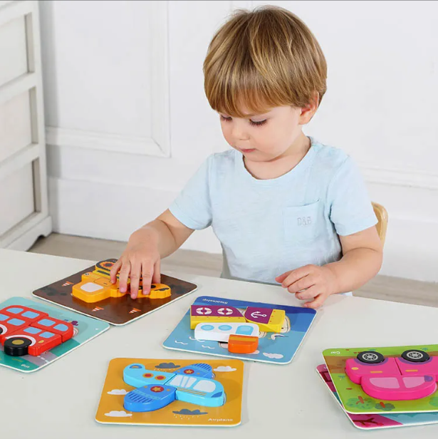 Malček sestavlja lesene Montessori puzzle z vozili za razvoj fine motorike, del paketa MINI 24m+
