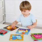 Malček sestavlja lesene Montessori puzzle z vozili za razvoj fine motorike, del paketa MINI 24m+