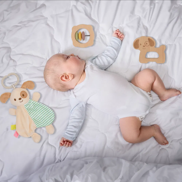 Dojenček na odeji ob lesenih Montessori igračah – rattle in kužek na kolesih, del paketa MINI 6m+